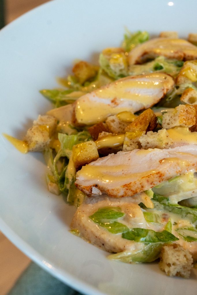 Caesar salad: lattuga, pollo alla piastra, scaglie di grana, crostini di pane e caesar dressing
